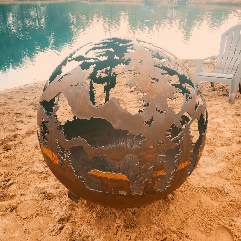 a fire pit sphere by the lake in spring